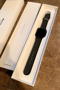 an apple watch sits in its box on the table next to it's packaging