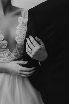 black and white photo of bride and groom holding each other's arms with their wedding rings