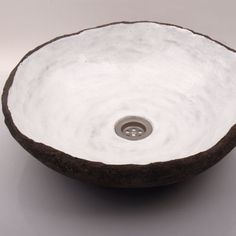 a white and brown bowl with a drain in it