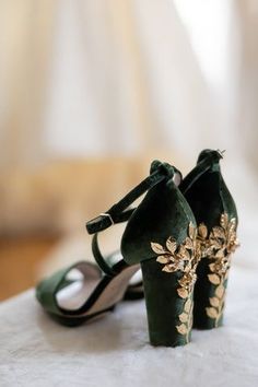 a pair of green high heeled shoes sitting on top of a white tablecloth