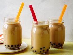 three mason jars filled with liquid and topped with straws