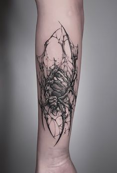 a black and white tattoo on the leg of a person with a spider crawling through it