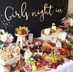 a table topped with lots of different types of fruit and snacks next to a sign that says girl night in