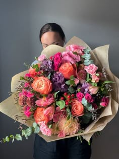 a woman holding a large bouquet of flowers