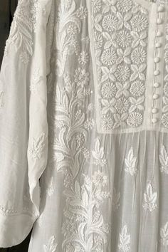 This White Muslin Silk Handcrafted Lucknowi Chikankari A Line Kurta Long Dress is a stunning piece of art. The beautiful white  dress  is perfect for any special occasion. The luxurious fabric and intricate Lucknowi Chikankari embroidery make it a timeless piece that will never go out of style.    Muslin silk    Length 48" inches   Long sleeves 18" inches  Round neck  A line   Lucknowi chikankari hand embroidered    Dry Clean    Fit:     True to size    Inside Margin:     No    Disclaimer:   Sin White Lucknowi Kurta, Lakhnavi Suits, Office Kurti, Lucknowi Chikankari Suits, White Chikankari Kurta, Lucknowi Embroidery, Phulkari Pants, Cotton Kurties, Japan Clothing