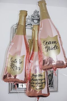 three pink champagne bottles with gold foil wrapped around them and the words team bride on each bottle