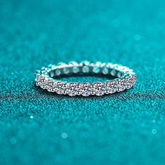 a diamond ring sitting on top of a blue surface