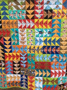 a colorful quilt is hanging on the wall