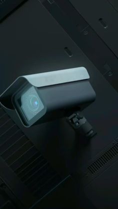 a camera attached to the side of a metal object on top of a black surface