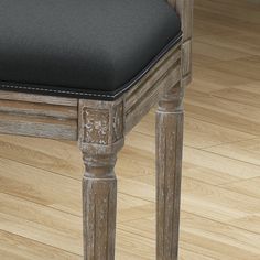 a wooden chair with a black cushion on it's seat and wood flooring