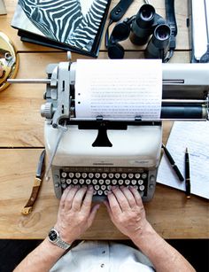 an old fashioned typewriter sitting on top of a wooden table