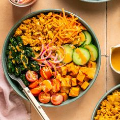 two bowls filled with different types of food on top of a wooden table next to utensils