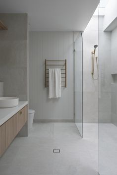 a bathroom with a glass shower door, sink and toilet next to a stand up shower