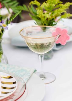 a table set with plates, silverware and flowers