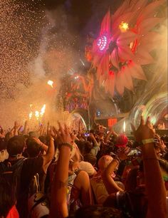 a large group of people at a concert with fireworks and confetti in the air