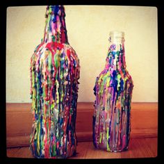 two colorful vases sitting on top of a wooden table