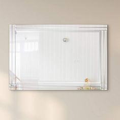 a bathroom mirror hanging on the wall above a sink