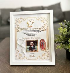 a white framed photo with gold trim and an image of a baby in the center