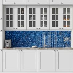 a white kitchen with blue speckles on the backsplash and counter tops