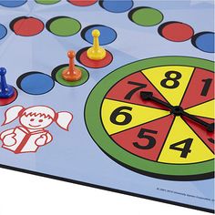 a close up of a clock on a board game with numbers and figures around it