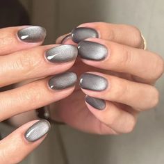 a woman's hands with grey and silver manicures on their nails,