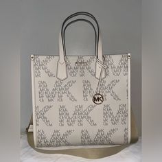 100% Authentic Guaranteed Brand New With Tags Michael Kors Maple Large Ns Logo Tote Vanilla/Cream Msrp $ 398.00 Style # 38h3g7mt3y Color: Vanilla/Cream Details - Large Mk Logo Print Throughout - Dual Top Handles - 5.75" Drop - Goldtone Hardware - Adjustable & Removable Crossbody Strap - 14" - 22.5" Drop - Hanging Mk Leather Charm - 14.25" W X 14.25" H X 5" D - Inside Has Large Zip Pocket, 2 Slip Pockets - Imported White Michael Kors Shoulder Bag With Logo, Cream Logo Tote Shoulder Bag, Cream Tote Shoulder Bag With Logo, Chic Cream Bags With Logo, White Logo Shoulder Bag For Errands, Cream Shopping Bag With Logo, Cream Bags With Logo For Shopping, Cream Shoulder Bag With Logo For Shopping, Designer Cream Shoulder Bag With Logo