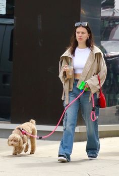 a woman walking her dog down the street