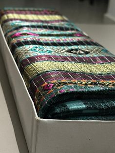 a close up view of a bench made out of colorful fabrics and fabric materials