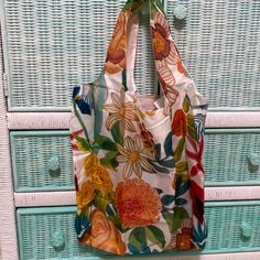 a floral bag hanging on a wicker cabinet