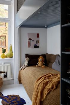 two stuffed animals sitting on top of a bed in a room with white walls and flooring