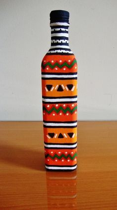 an orange and black bottle sitting on top of a wooden table