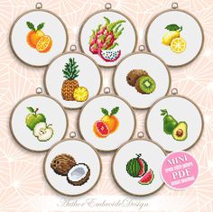 nine cross stitch fruits and vegetables are shown in the shape of small hoops on a pink background