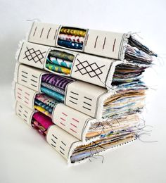 a stack of different types of fabric on top of each other with thread in them