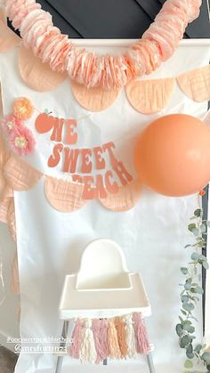 an orange balloon and some pink decorations on a white sheeted backdrop with the words we sweet beach