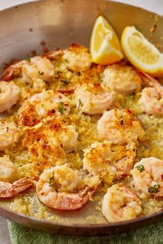 a skillet filled with shrimp and lemon slices