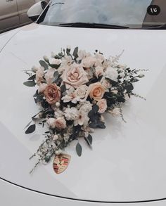 a bouquet of flowers sitting on the hood of a car