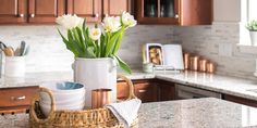 a basket with flowers sitting on top of a kitchen counter