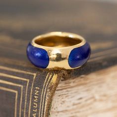 A vintage Van Cleef & Arpels Band featuring the loveliest deep blue enamel and a sweet little button detail. Button, belt, or buckle - whatever she is, we are into it.This ring comes to us from the late 1960s, an era where VCA was creating high end jewelry for the likes of Princess Grace of Monaco or Empress Farah Pahlavi of Iran. It is believed that the 1960's and the 1970's are some of VCA's most creative and influential years as they seemed to really capture the luxurious and glamorous je Blue Enamel Polished Round Ring, Blue Polished Enamel Ring, Blue Enamel Ring With Polished Finish, Blue Hallmarked Enamel Ring, Classic Blue Enamel Jewelry, Blue Heirloom Enamel Jewelry, Elegant Blue Enamel Ring, Vintage Blue Enamel Rings, Luxury Blue Enamel Ring For Wedding