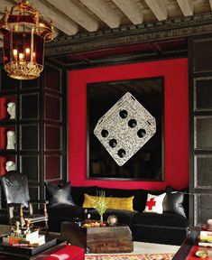 a living room with red walls and black furniture