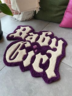 two purple and white rugs sitting on top of a floor next to a plant