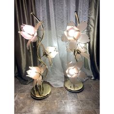 two lamps with flowers on them sitting next to each other