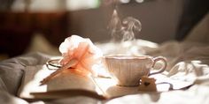 an open book and cup with steam rising from it