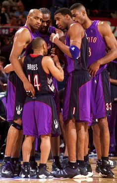 several basketball players huddle together on the court