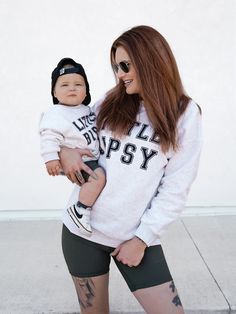 Calling all LB superfans! The most stylish way to show your LB pride is our Collegiate Crewneck, featuring classic 'Little Bipsy' text + the familiar, cozy feel of your favorite college sweatshirt. Pair it with our Athletic Ribbed Biker Short or Legging to rep LB from head to toe! Color: Grey 'LITTLE BIPSY' printed on the front Ribbed neckline, cuffs, and bottom hem Rollable + cinched wrist cuffs Material + Wash: 86.7% cotton | 13.3% polyester Do not bleach Machine wash cold with like colors Dry Casual Game Day Tops With Letter Patch, Casual Letter Patch Tops For Game Day, Casual Tops With Letter Patch For Game Day, Casual Crew Neck Sweatshirt With Letter Patch, Fall School Spirit Sweatshirt With Text Print, Trendy College Sweats With Letter Print, Casual Game Day Sweatshirt With Text Print, Casual Sweatshirt With Text Print For Game Day, Casual Text Print Sweatshirt For Game Day