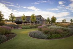 a large building sitting on top of a lush green field next to a golf course