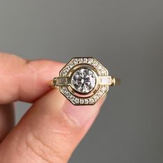 a woman's hand holding an engagement ring with diamonds on the side and in the middle