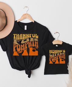 "Embrace the heartwarming spirit of fall and the joy of shared moments with our charming matching shirts for Mama's and their little ones. Our \"Thankful For Pumpkin Pie\" shirt for moms and the adorable \"Momma's Little Pumpkin Pie\" shirt for kids are the perfect duo for celebrating the season of gratitude and togetherness. These shirts embody the essence of autumn, capturing the special bond between mothers and their children. Whether you're exploring pumpkin patches, savoring family feasts, or simply enjoying the crisp air, these matching outfits will infuse your moments with an extra layer of love and connection. We are offering UNISEX clothing options in a variety of sizes from T-Shirt and Sweatshirt styles including the Super Soft Bella Canvas 3001 T-Shirt (100% cotton) to baby size Family Matching Short Sleeve Tops For Fall, Family Letter Print Tops For Fall, Fall Tops With Letter Print, Cute Name Print Tops For Fall, Cute Tops With Name Print For Fall, Fall Short Sleeve Tops For Gifts, Family Matching Black Tops For Fall, Black Family Matching Tops For Fall, Fall Short Sleeve Tops For Gift