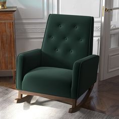 a green chair sitting on top of a wooden floor next to a white wall and door