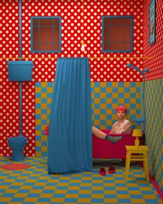 a woman sitting in a chair with polka dots on the walls and curtains over her head