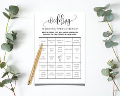 a printable wedding speech ring game on top of a table next to eucalyptus leaves